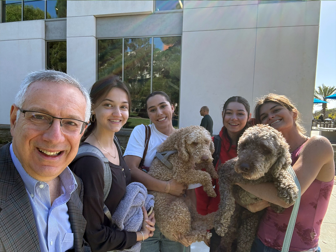 Chancellor Assanis with UCSB students and two dogs
